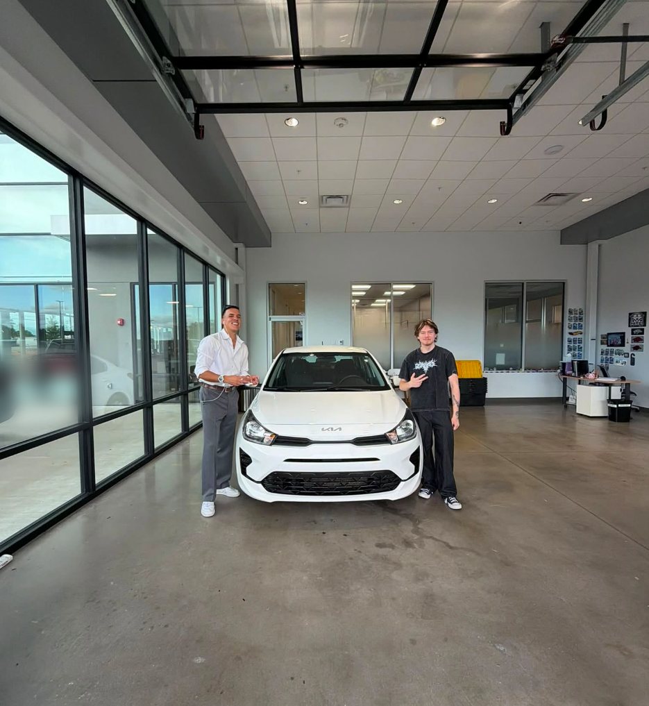 Mario and a client with a white hatchback on delivery day